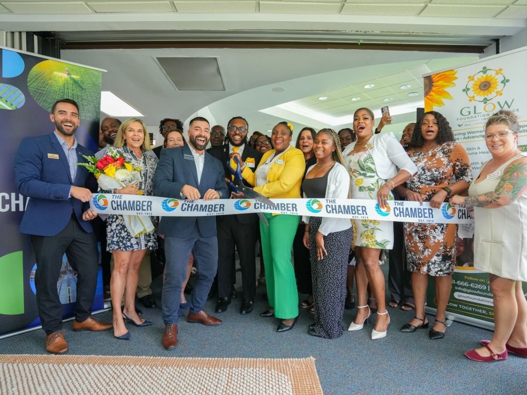 Group of diverse people at ribbon-cutting event celebrating new business opening.