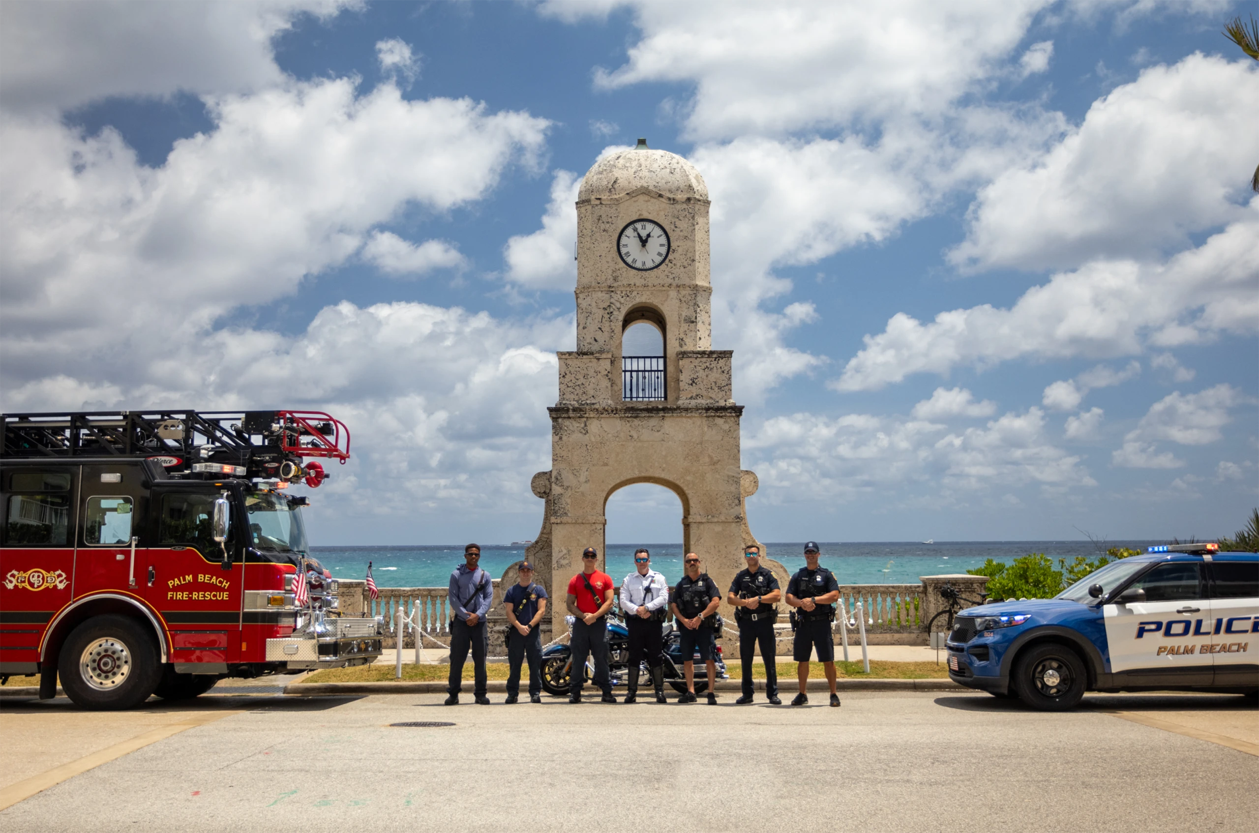 Group of police officers and firefighters positioned in front of Worth Avenue Clock Tower in Palm Beach.