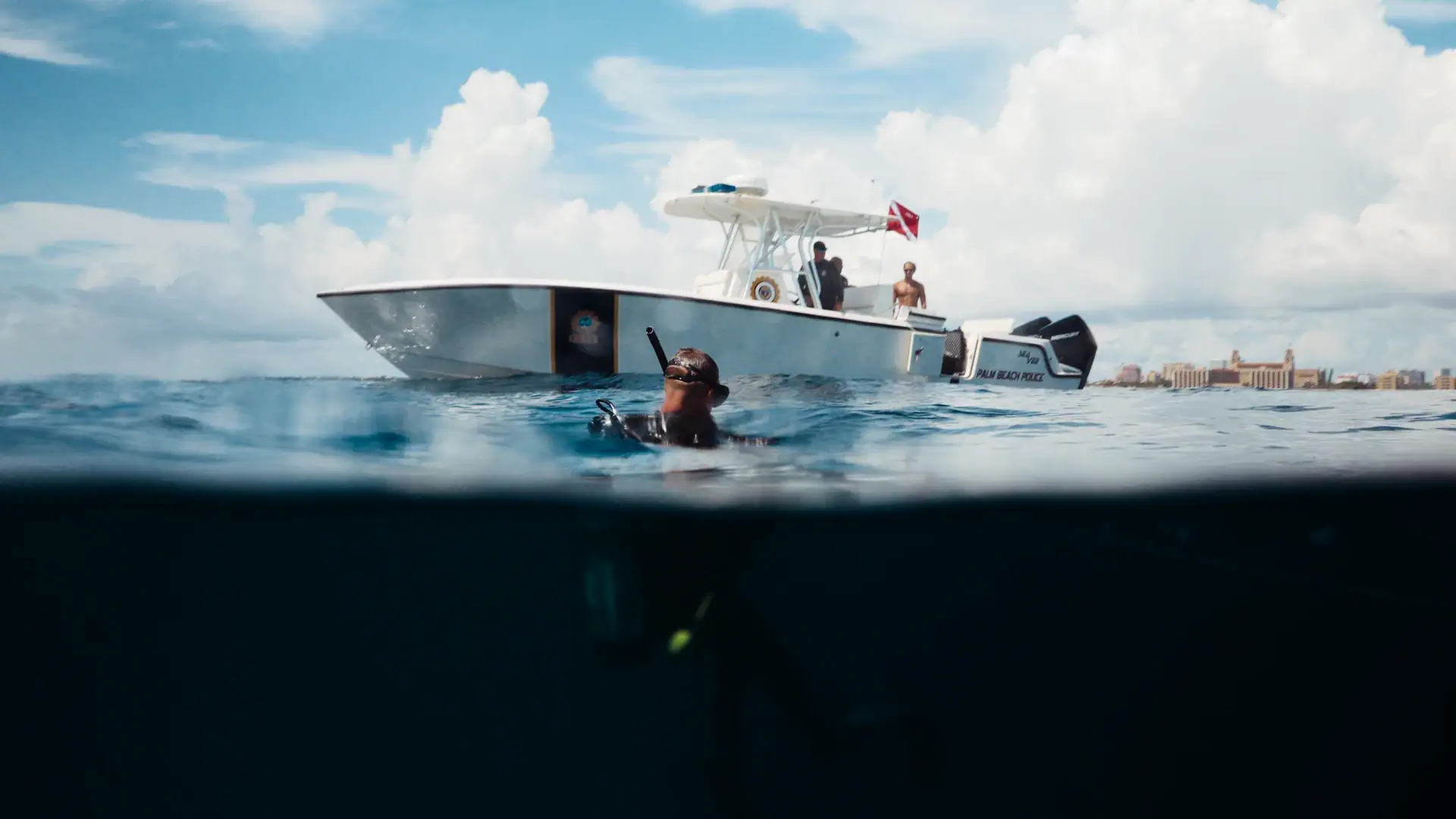Michael Ostrander swims in the ocean beside a boat.