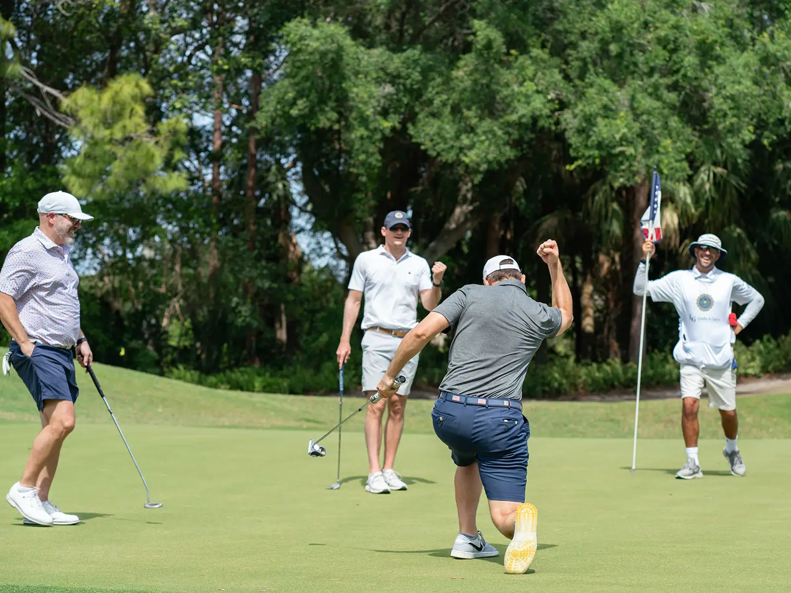 Golf players celebrating on the green during a tournament at Palm Beach Golf Course.