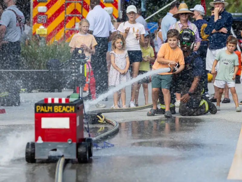 Children and firefighters participate in a fire safety demonstration in Palm Beach.