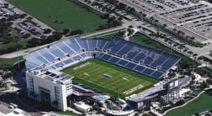 Aerial view of a football stadium with green field and surrounding seating areas.