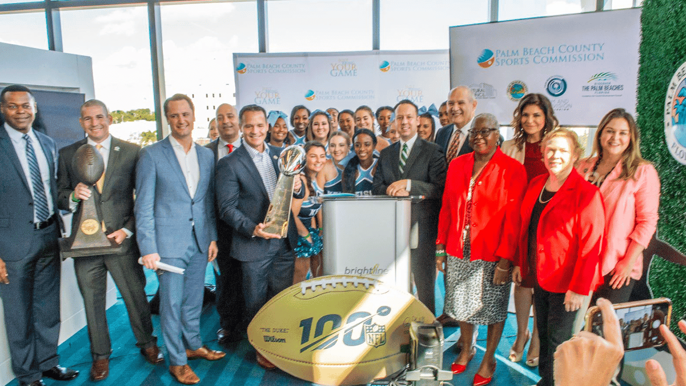 Group of people celebrating Palm Beach County Sports Commission achievements at an event.