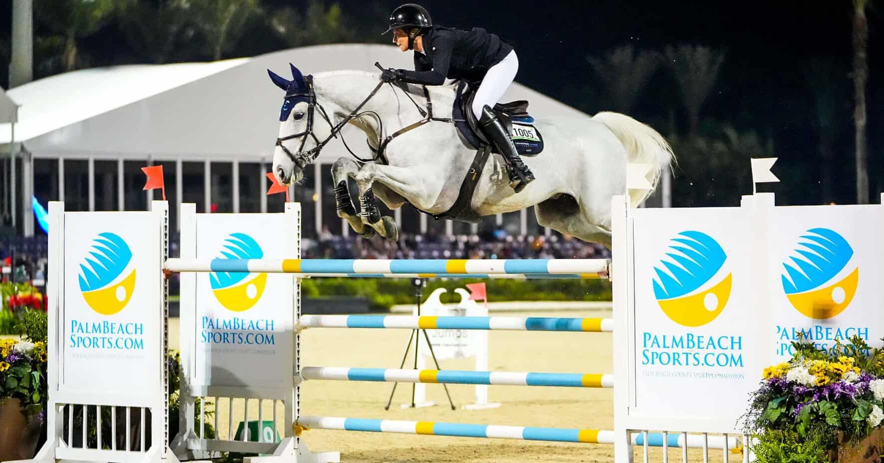 Equestrian rider and horse jumping over obstacle at Palm Beach County event.