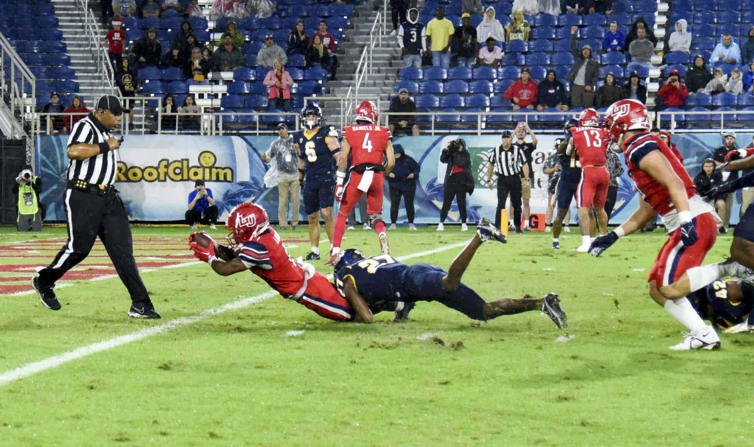 Football player dives for the ball during a game at Boca Raton Bowl Week.