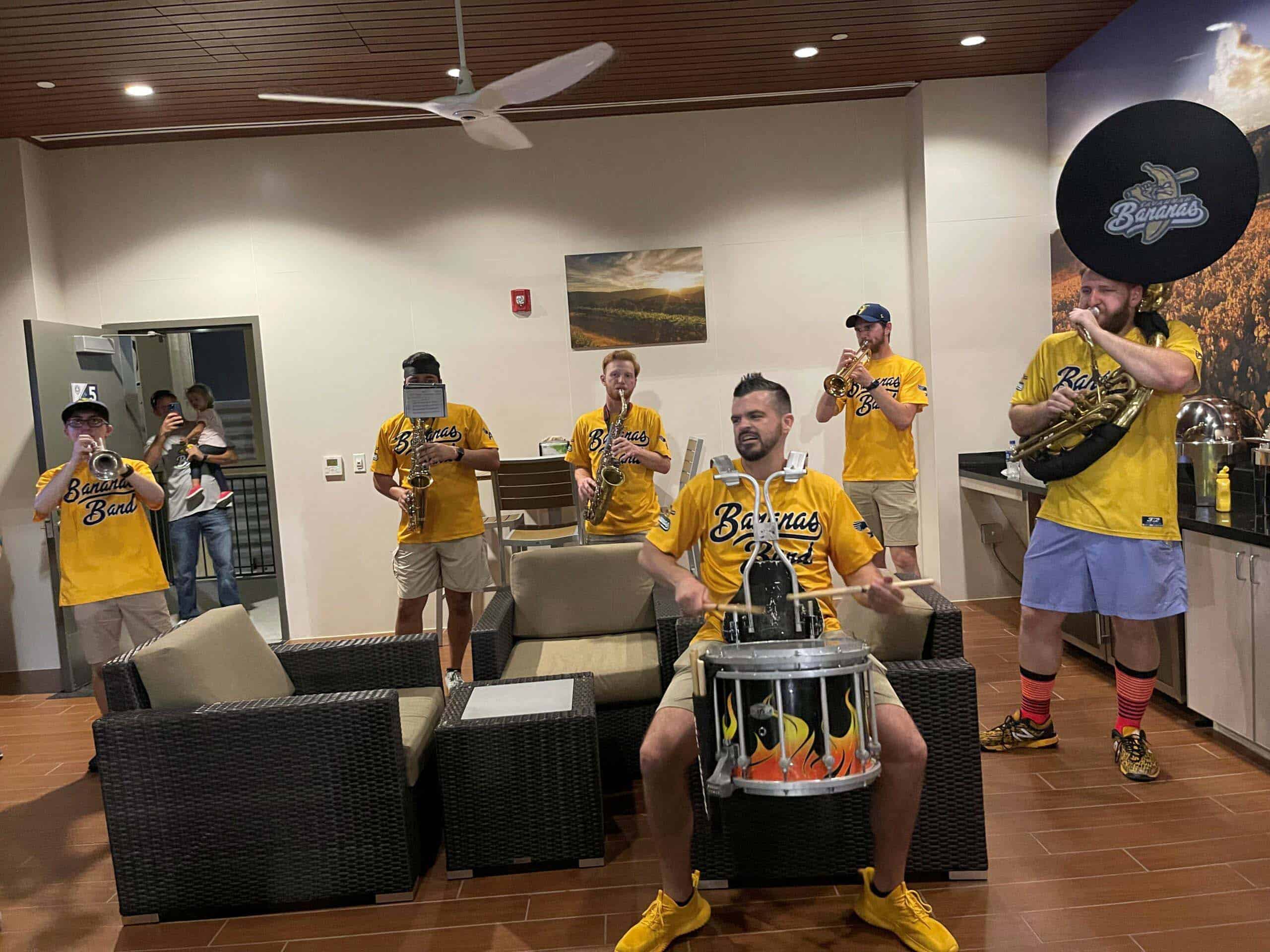 Savannah Bananas band performing at Palm Beach County sports event in yellow jerseys.