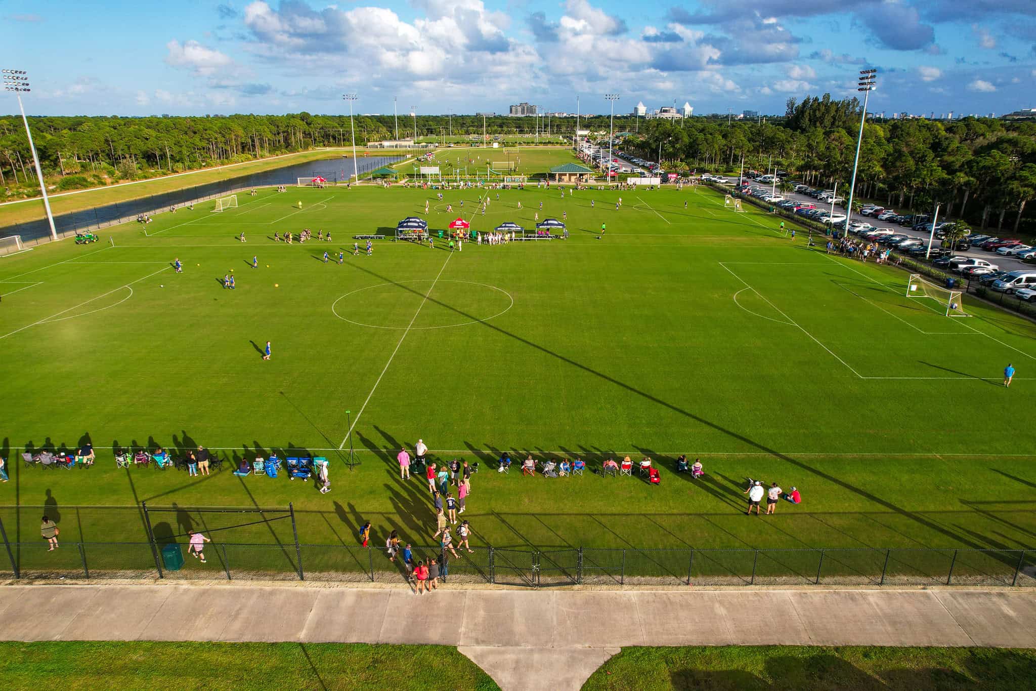 Soccer field at a sports complex in Palm Beach County with players and spectators.