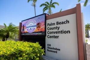Palm Beach County Convention Center sign with palm trees and digital display.