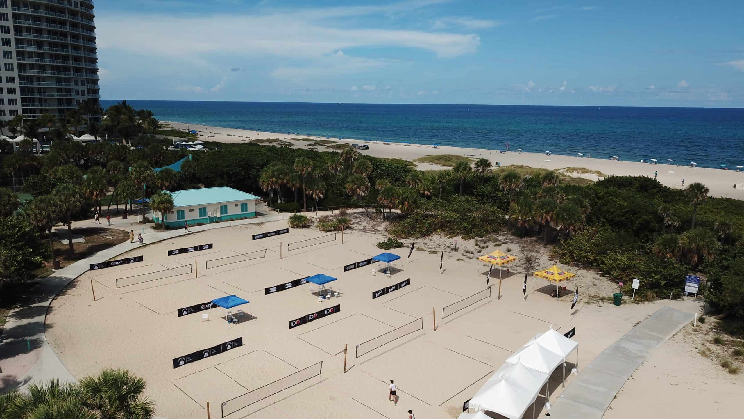 Palm Beach County beach tennis courts by the ocean with palm trees and blue sky.