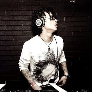 Takatsugu Wada wearing headphones, DJing at an event on Partybody.