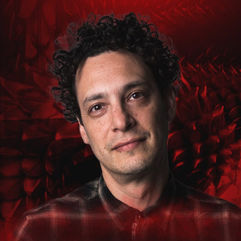 Man with curly hair and a subtle smile on red floral background on Partybody.
