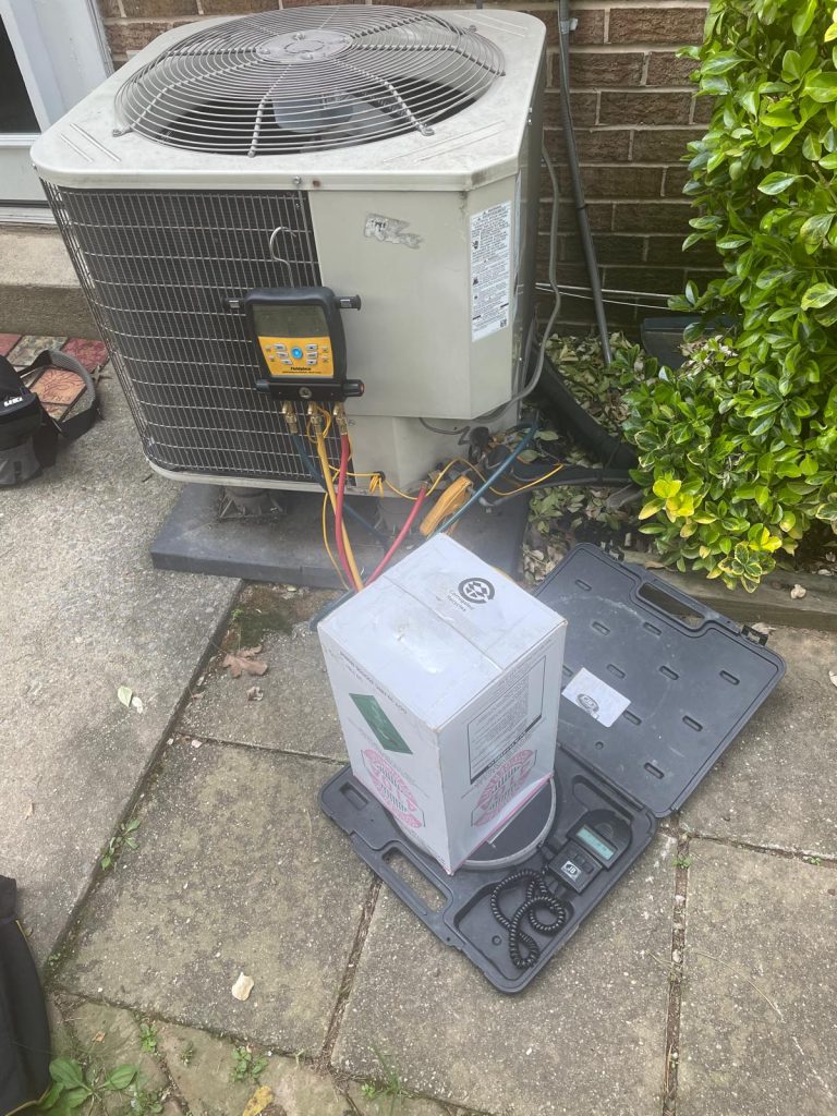 Outdoor air conditioning unit with gauges and a box on a scale.