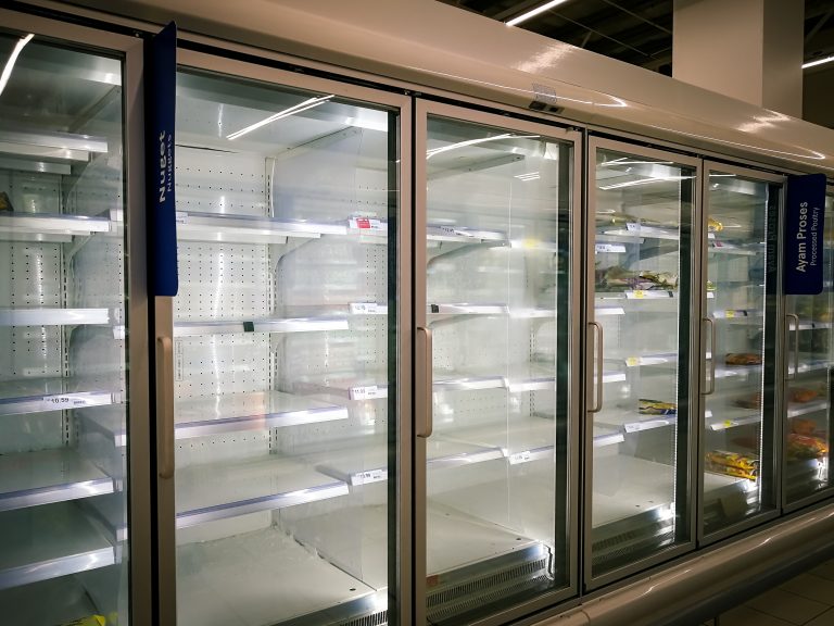 Empty refrigerated display cases in a supermarket aisle