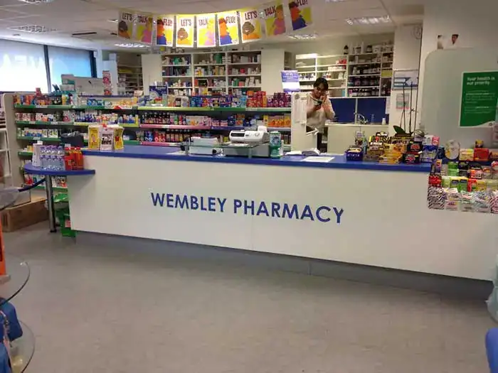 Interior of Wembley Pharmacy with staff and shelves of medicines.