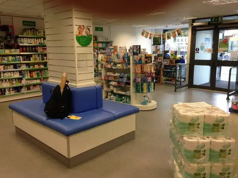 Modern pharmacy interior at Physio-medicine London with shelves and seating area.