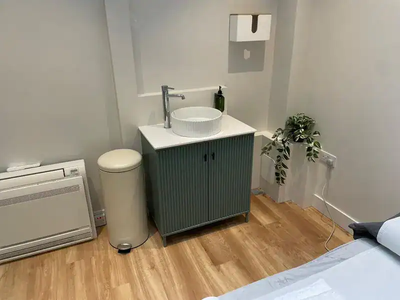 Physio-medicine London treatment room with sink, cabinet, and relaxing environment.