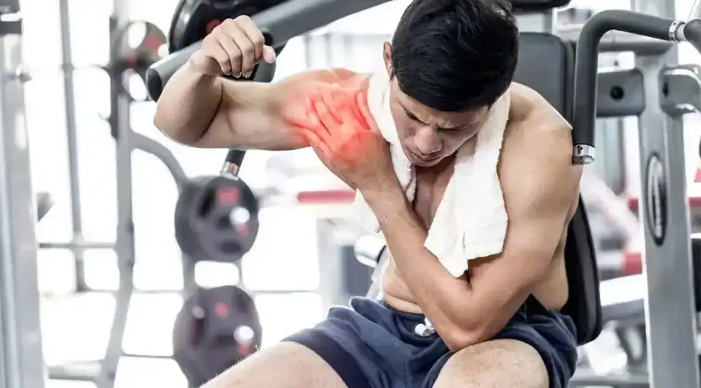 Man experiencing shoulder pain after workout at Physio-Medicine London.