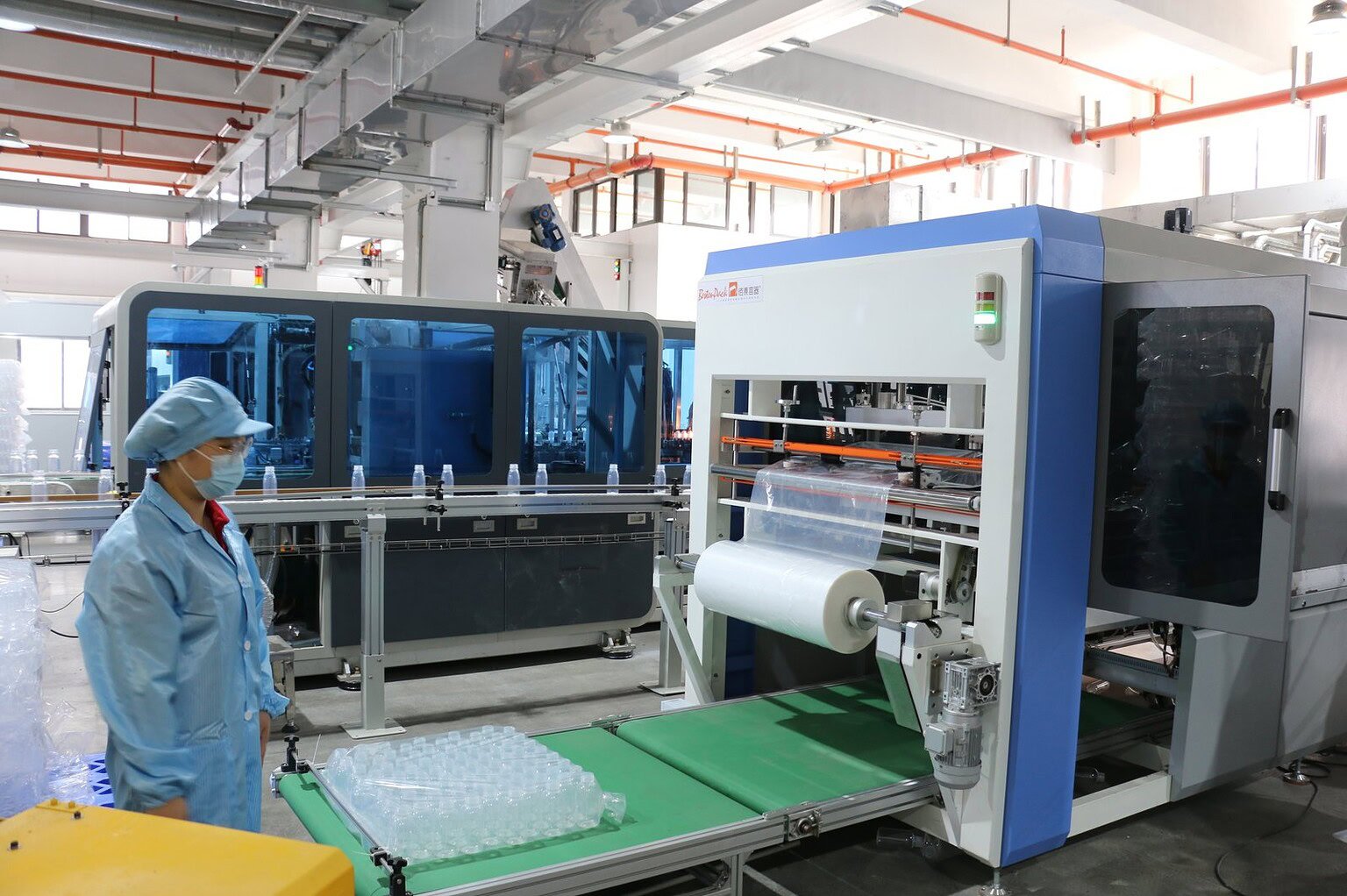 High-tech bottle manufacturing machinery in a factory setting.