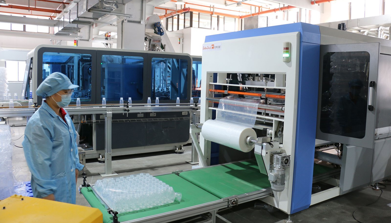 High-speed plastic bottle manufacturing machine in a factory setting.