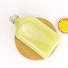 Clear PET plastic bottle with a silver cap on a wooden board, with a slice of lemon in the background.