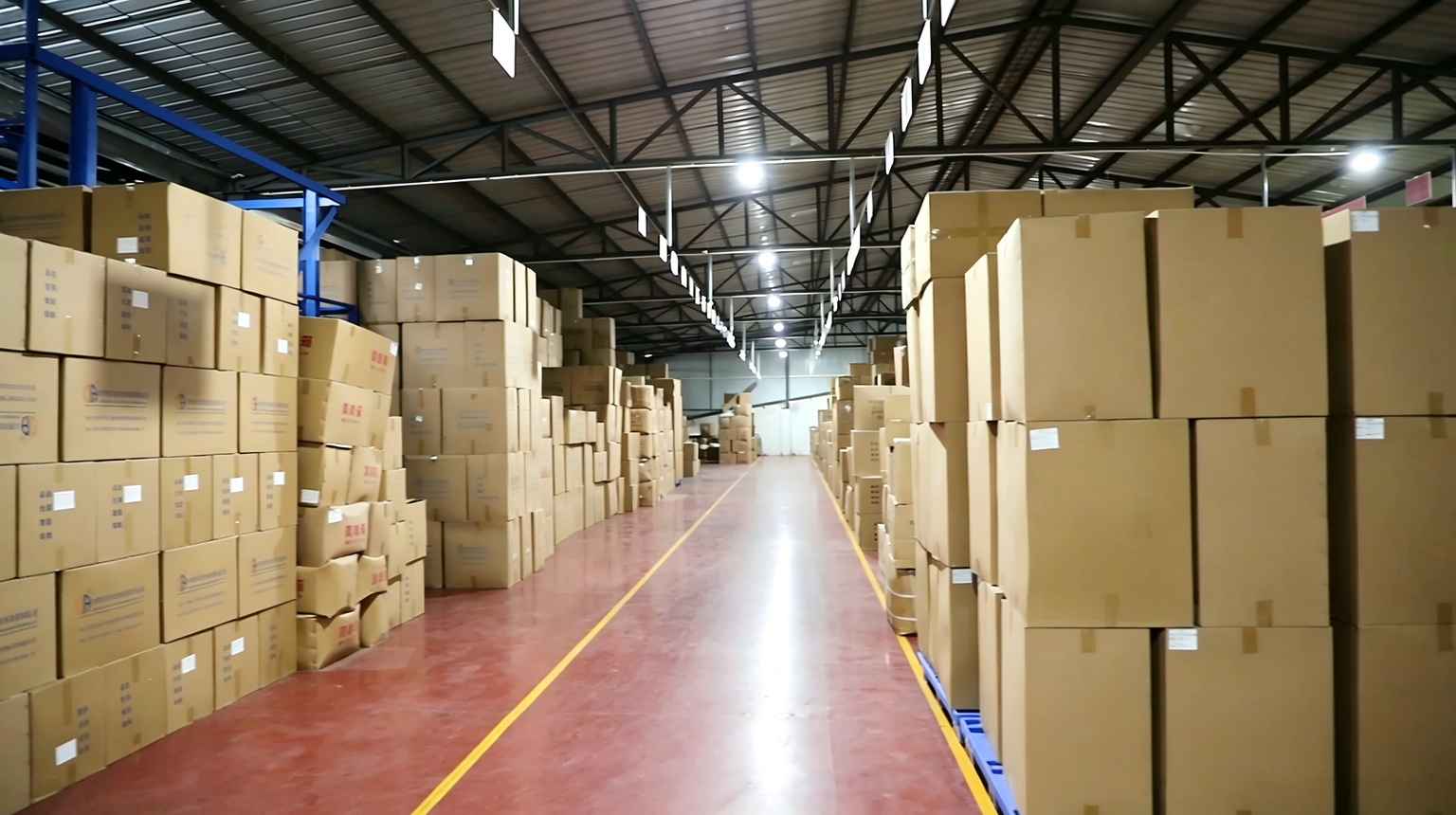 A warehouse with neatly stacked cardboard boxes for glass and plastic containers.