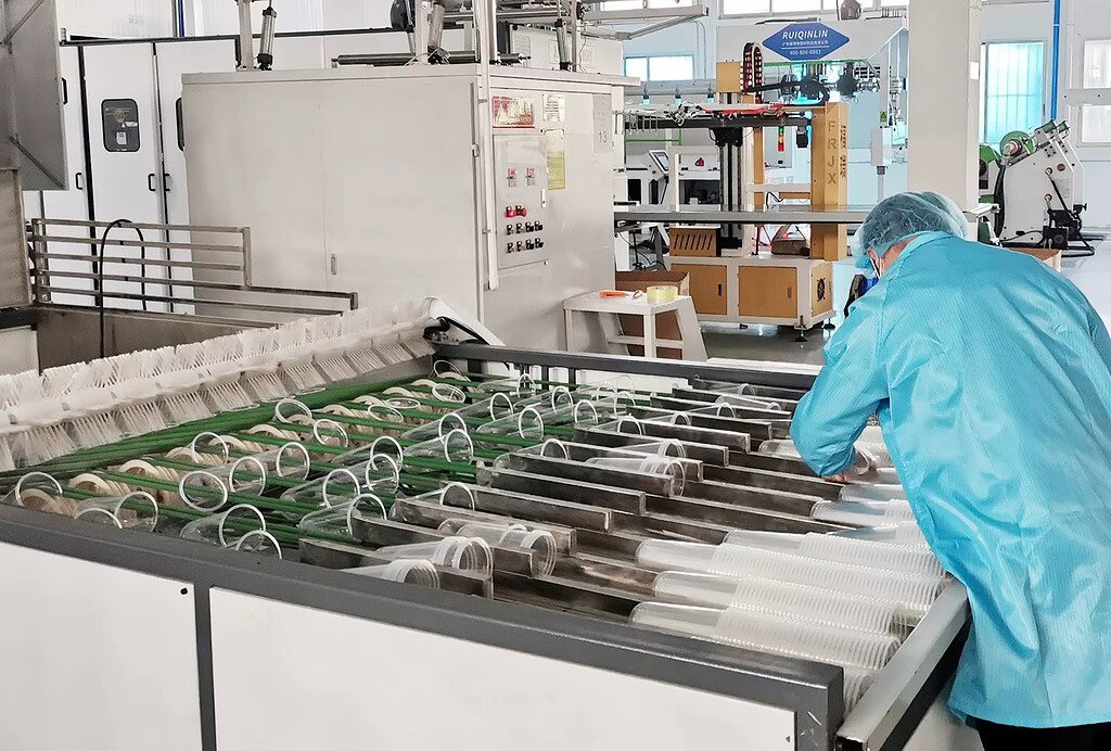 Manufacturing process of glass and plastic bottles in a factory setting.