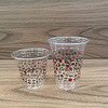 Transparent plastic cups with colorful printed patterns and text, suitable for beverages and events.