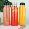 Clear plastic bottles with black, white, and yellow caps, filled with colorful liquids and fruit pie.
