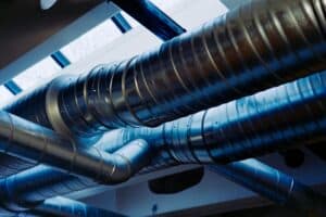 Close-up of metallic ventilation ducts used in advanced air purification systems for safer indoor air quality.