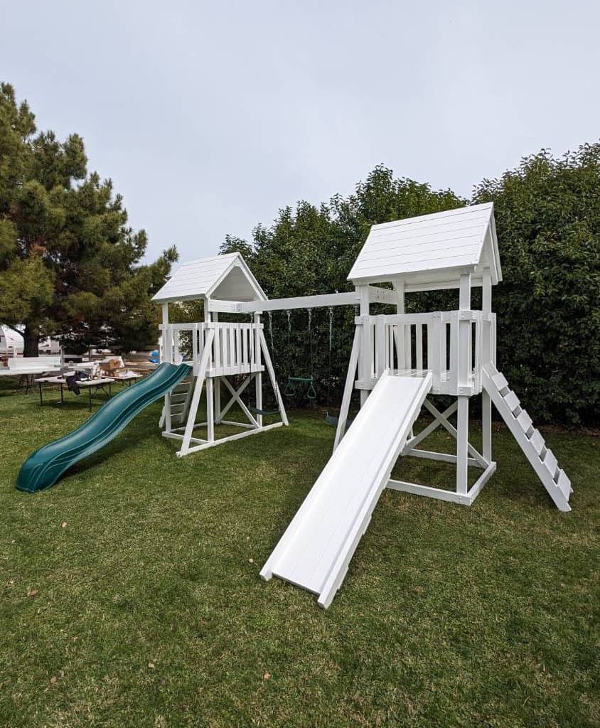 Watch Tower Vinyl playset in backyard with green grass and large tree.