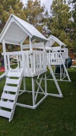 Watch Tower Vinyl playset in backyard with green grass and large tree.