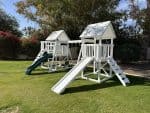 Watch Tower Vinyl playset in backyard with green grass and large tree.