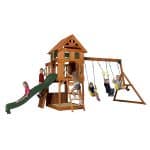 Children playing on a wooden outdoor playset with slide and swings in Texas.