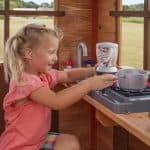 Young girl playing with pretend kitchen set at Echo Heights Playhouse in Texas.