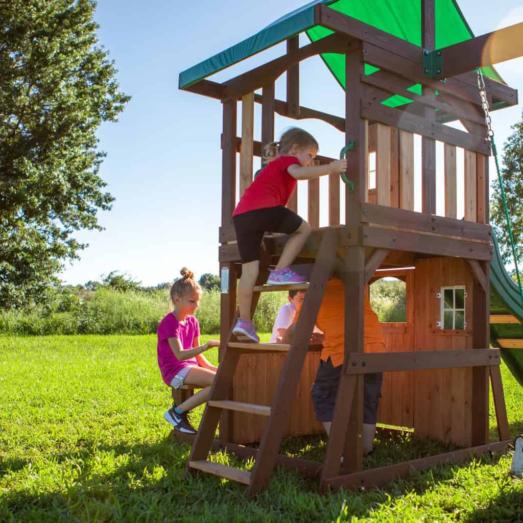 Children enjoying outdoor play on a wooden playset in Texas.