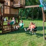 Children playing on Skyfort II with Spiral Tube Slide in a backyard.