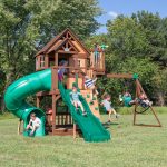 Children playing on Skyfort II playset with spiral slide and swings.