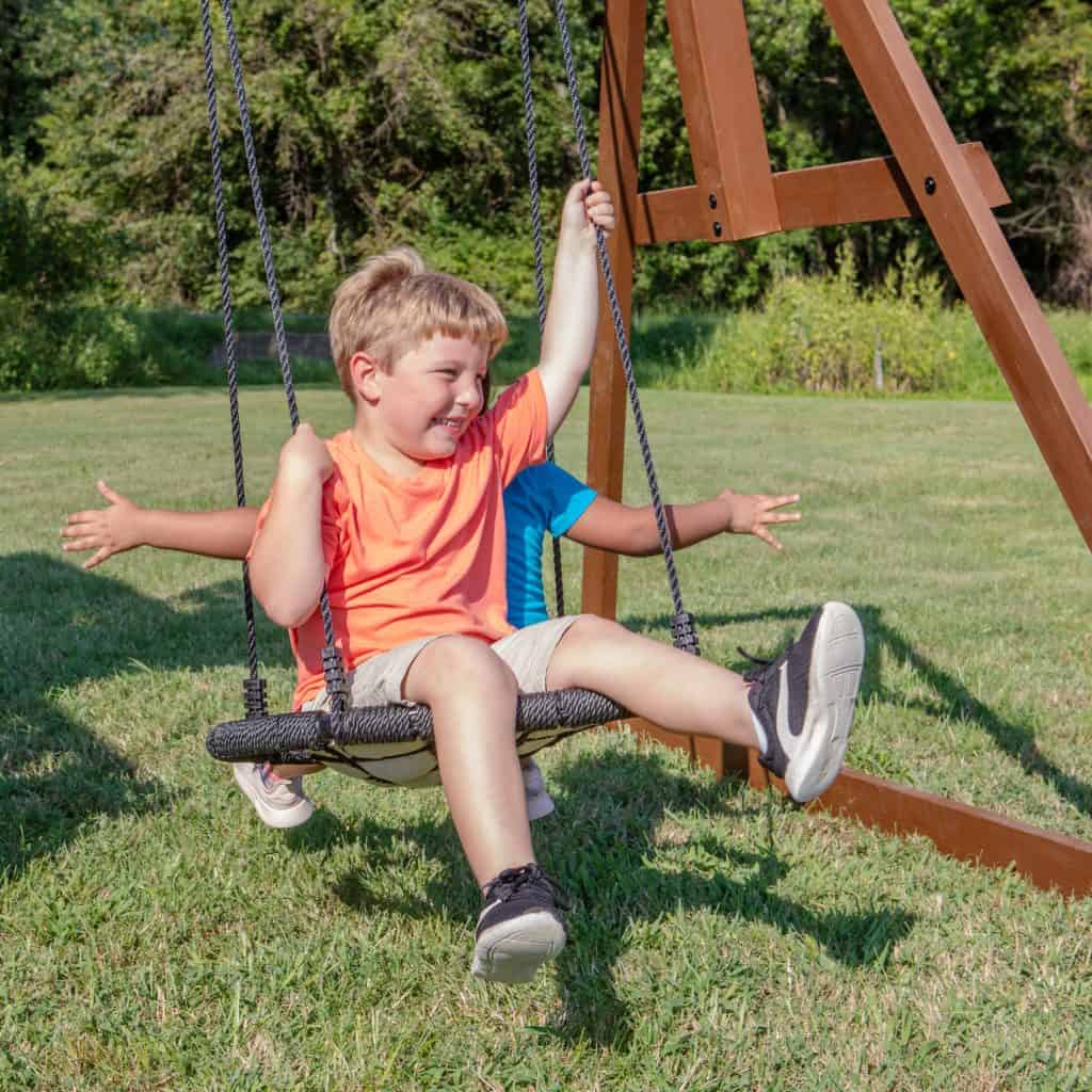 Children playing on Skyfort II swing set with spiral slide in Texas park.