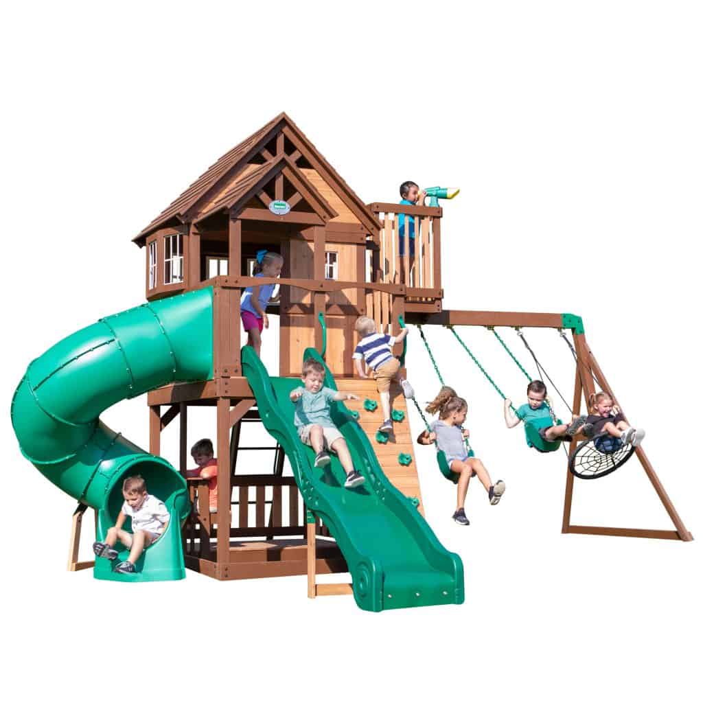 Children playing on a wooden outdoor playset with slide and swings.