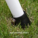 Close-up of the anchored foot plate of a Big Brutus heavy-duty metal A-frame swing set secured into the ground.