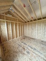 An interior view of an empty shed under construction.