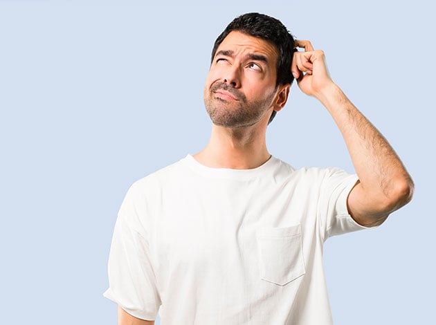 Man comparing white vinyl, wood, and metal swing set materials for durability and longevity.