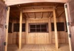 Front interior view of Titan Treehouse XL 14 swing set, showing wooden fort structure with enclosed walls and entryway.