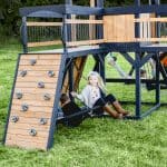 Children enjoying outdoor play on a wooden playground structure in Texas.