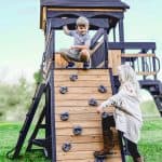 Children enjoying outdoor play on a wooden playground structure in Texas.