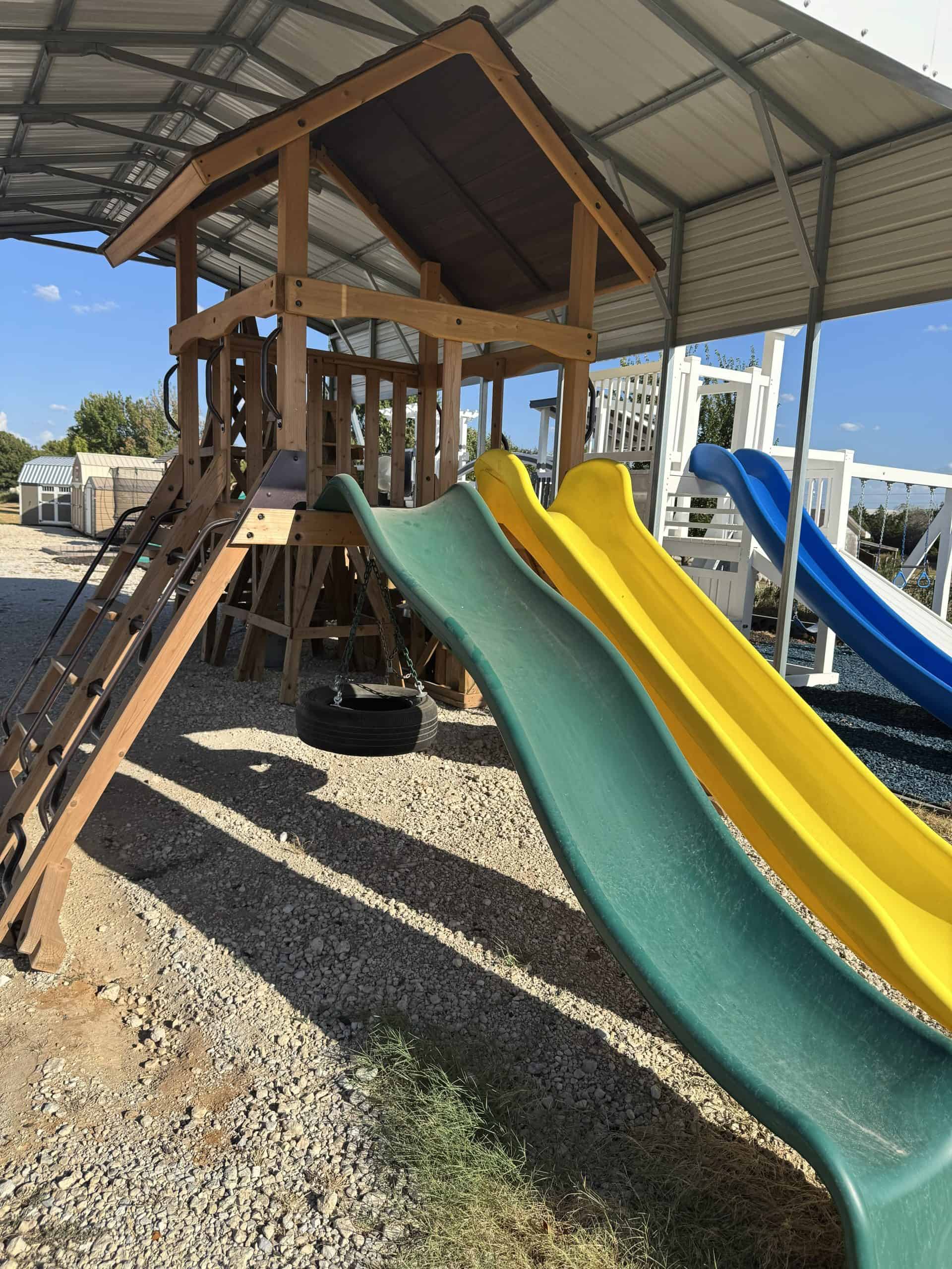 ASXL- Display-playground-for-sale Colorful outdoor playground with slides and a wooden play structure in Texas.