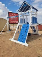 Colorful outdoor playground with slide, swings, and climbing wall for children.