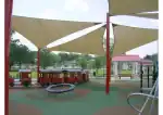 Colorful fabric shade sails over playground for kids in Texas.