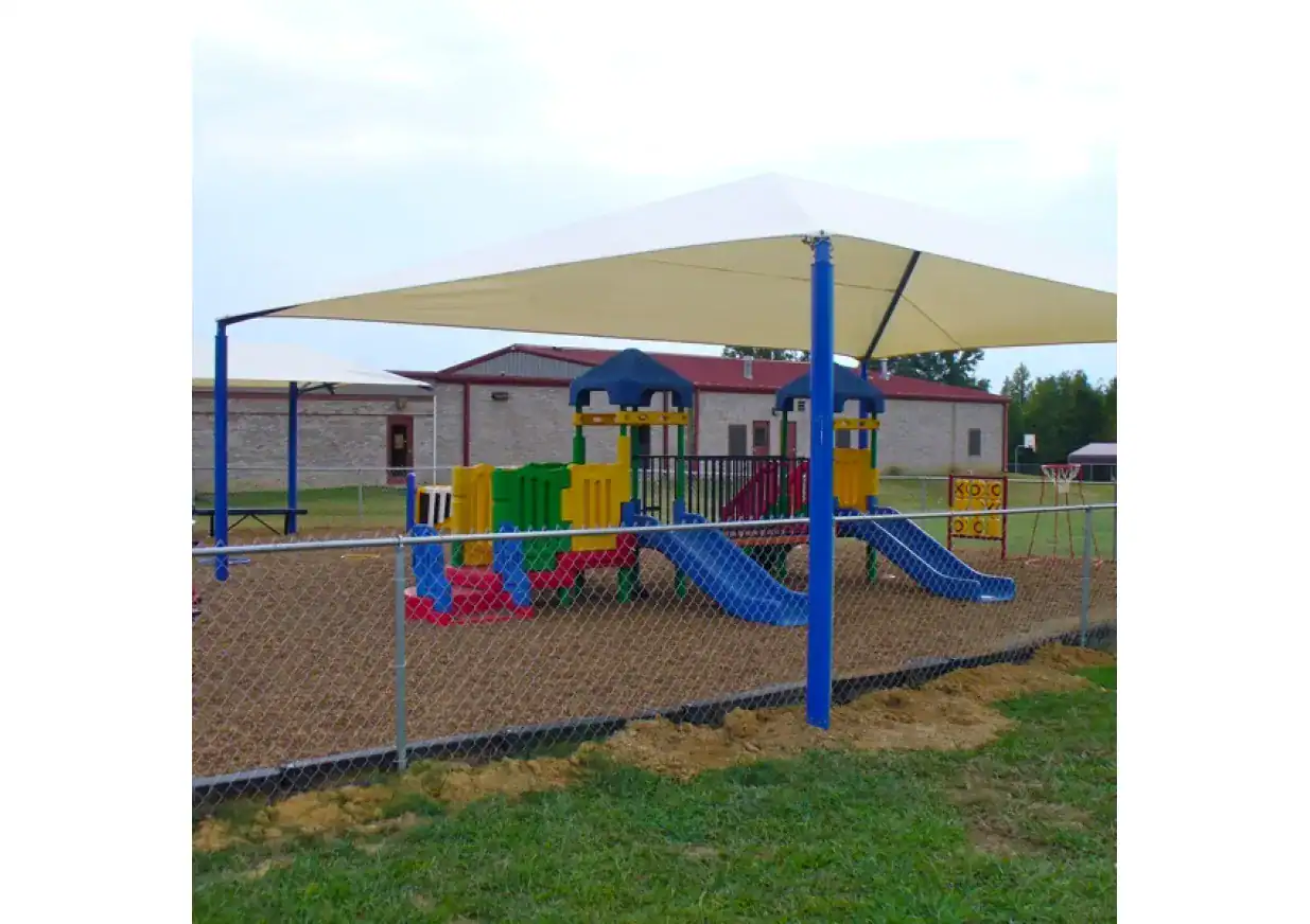 Rectangular Fabric Shade for Playground Large rectangular fabric shade over colorful playground equipment in Texas.