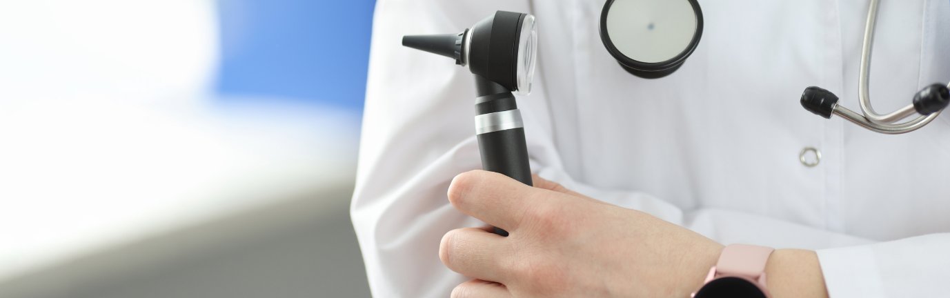 Medico con strumentazione per visita otorinolaringoiatrica